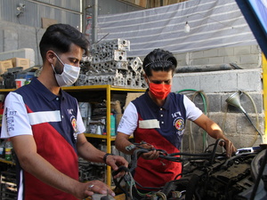 Iran. Afghan refugee and Iranian business partner in their automobile repair shop supported by UNHCR