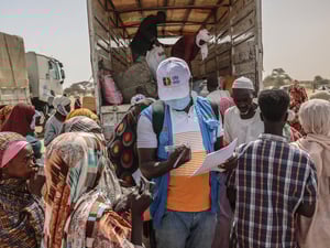 Un membro del personale dell'UNHCR controlla i documenti dei rifugiati appena arrivati dalla regione sudanese del Darfur settentrionale in un sito di transito vicino al valico di frontiera di Tine, in Ciad.