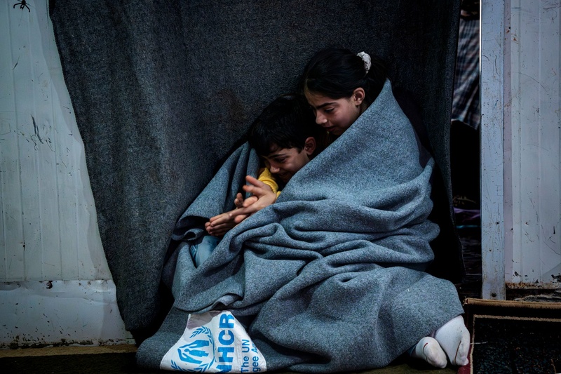 Jordan. Sundus, 11, cuddling her 6 years old brother Hisham with UNHCR blanket inside their shelter in Zaatari refugee camp.