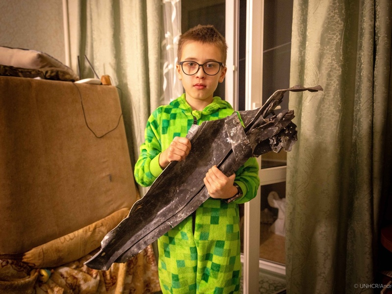 Bambino ucraino tiene in mano un frammento di drone