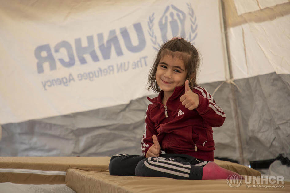 Bambina che sorride in un atenda di UNHCR