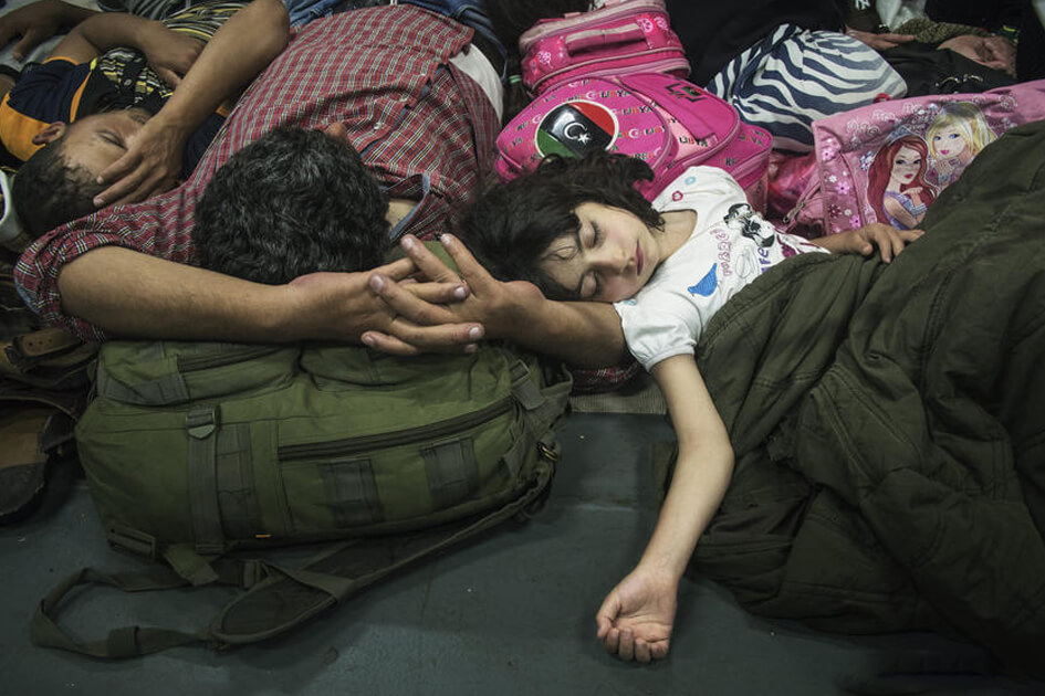 Una famiglia siriana esausta, dorme su una nave della guardia costiera italiana dopo essere stata salvata da una nave che stava tentando di attraversare il mediterraneo