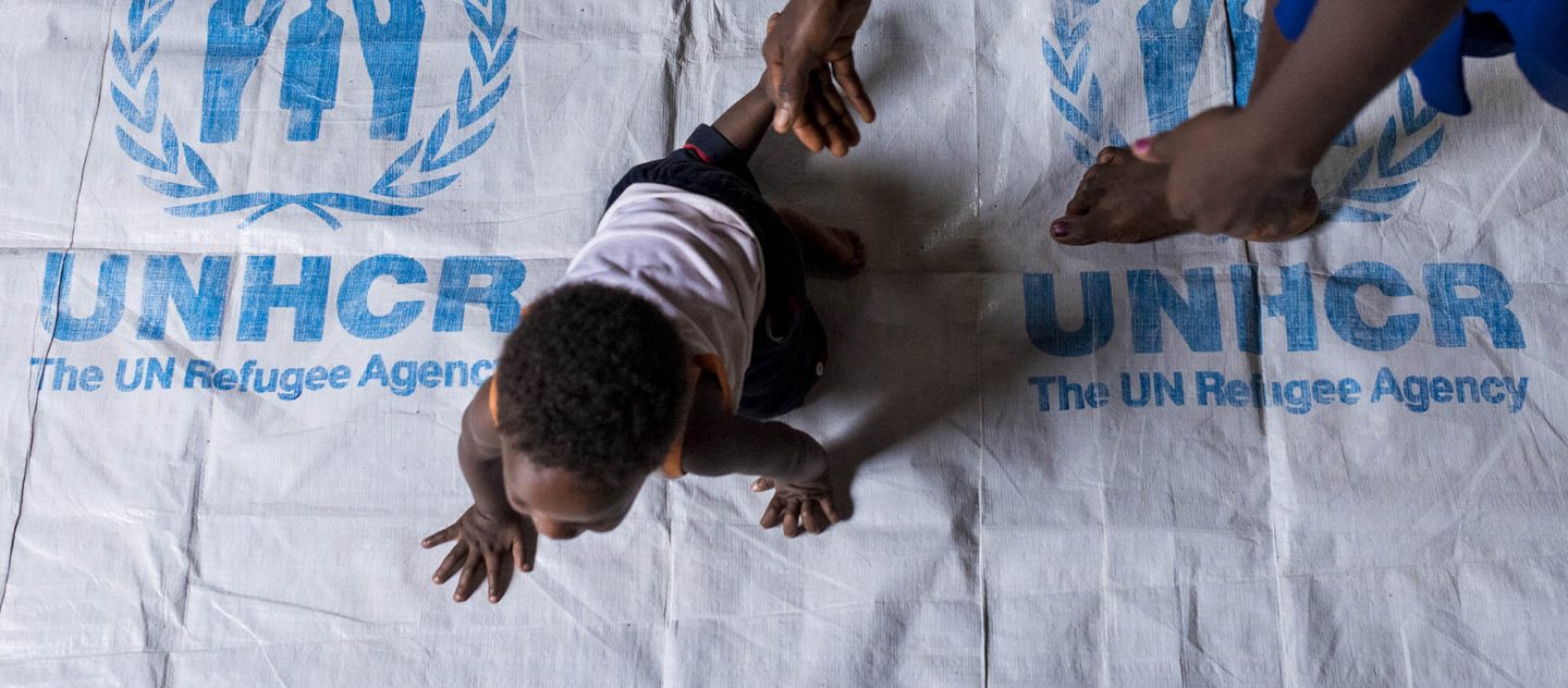 'Bambino che gattona su teli UNHCR