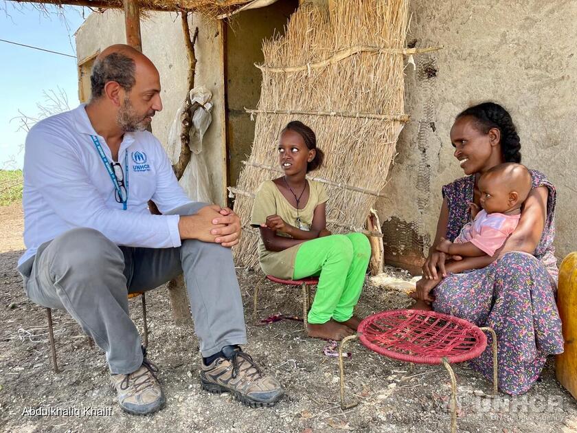 Sudan. UNHCR Protection Officer sits with an Ethiopian refugee family in Village 8.