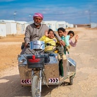 Abu Zainab, taking out his children for a ride, using his electrical bike