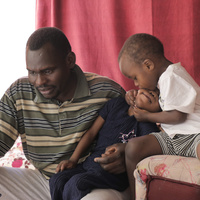 Sudanese refugee El Fadil with his daughter Areej, 6, and his son Ezzedine, 3, in their home in Amman.