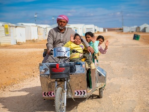 Abu Zainab, taking out his children for a ride, using his electrical bike