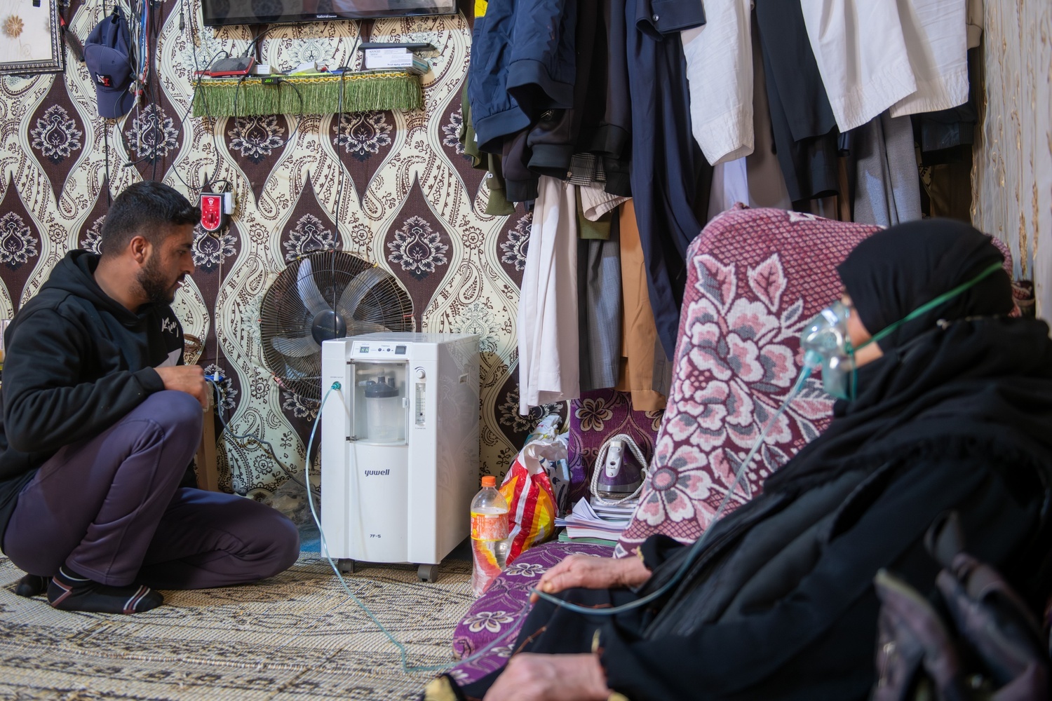 Saleh (23 YO) helping put up Fawzia's (his mother) ventilator on