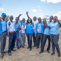 People in blue and grey uniform waving at the camera for a photo