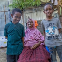 Fardowsa with her eight-year-old twin boys Abdidea (left) and Abdirazak (right). Fardowsa is a tap stand manager in Kakuma, and her work is to ensure her community has access to clean water