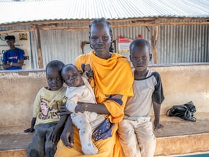 Nyamam, 25 with her three sons aged five, three and six months, poses for a photo at the Kalobeyei Reception Centre in Kakuma.