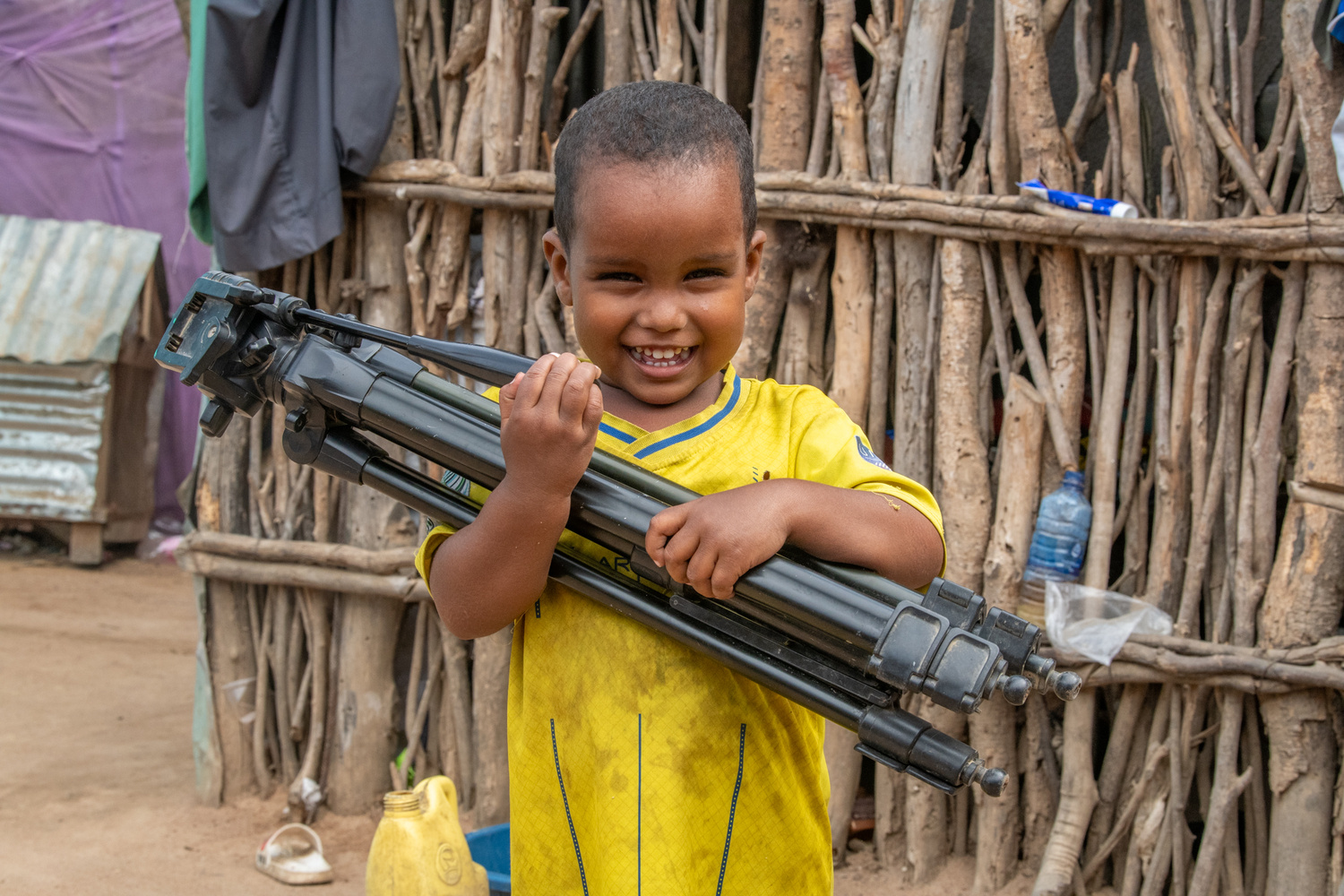 Smiling boy holding a tripod