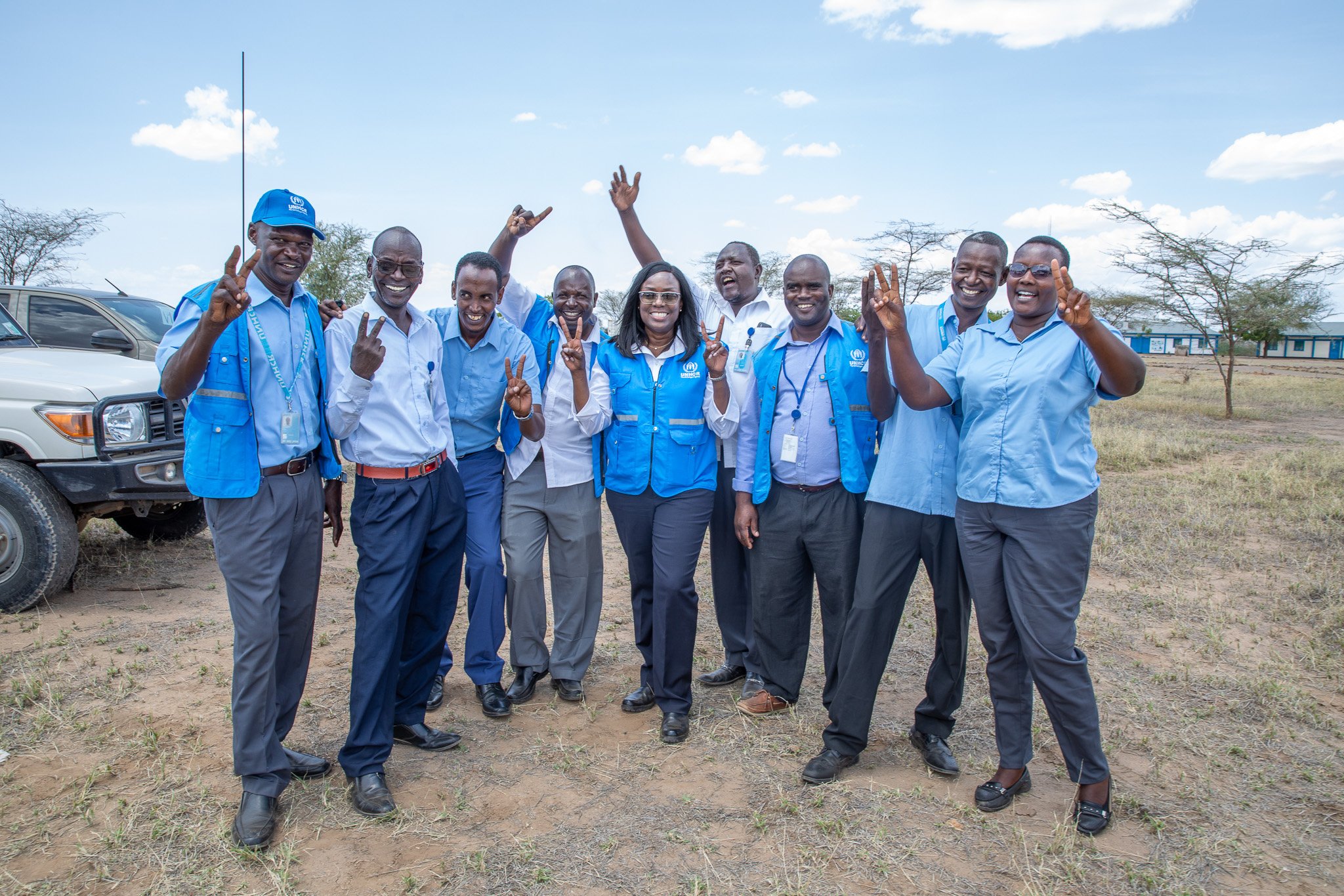 People in blue and grey uniform waving at the camera for a photo