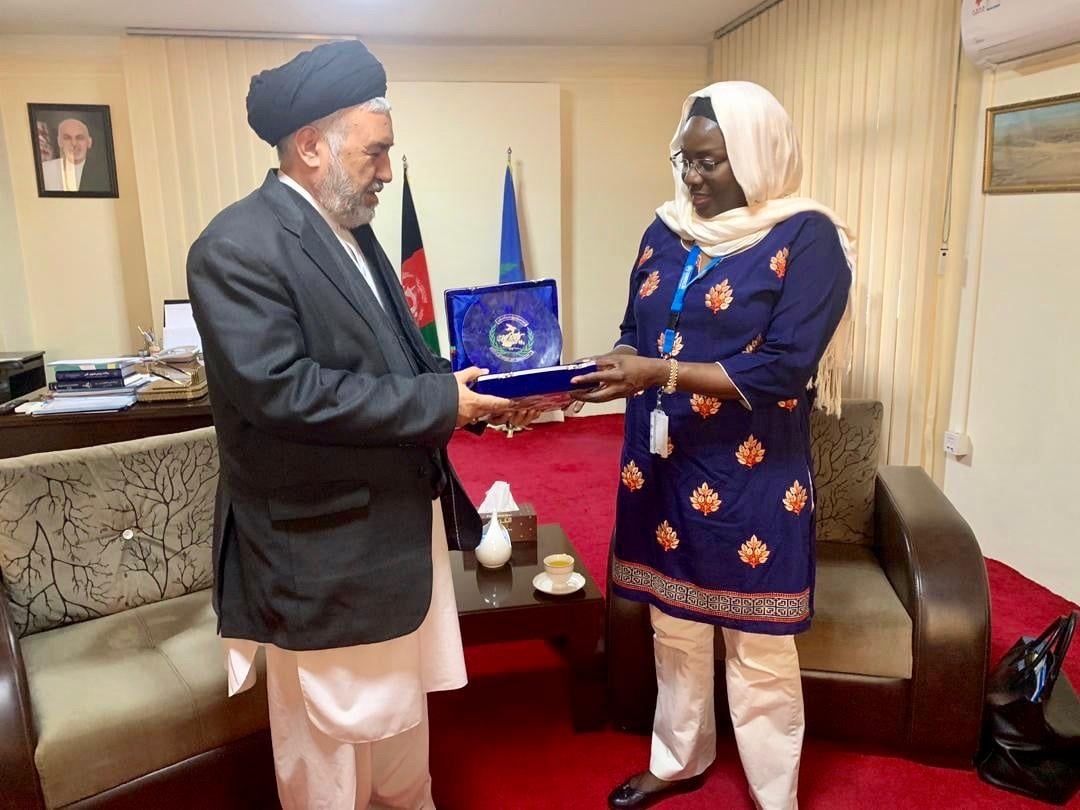 Aman and a woman holding a document in an office