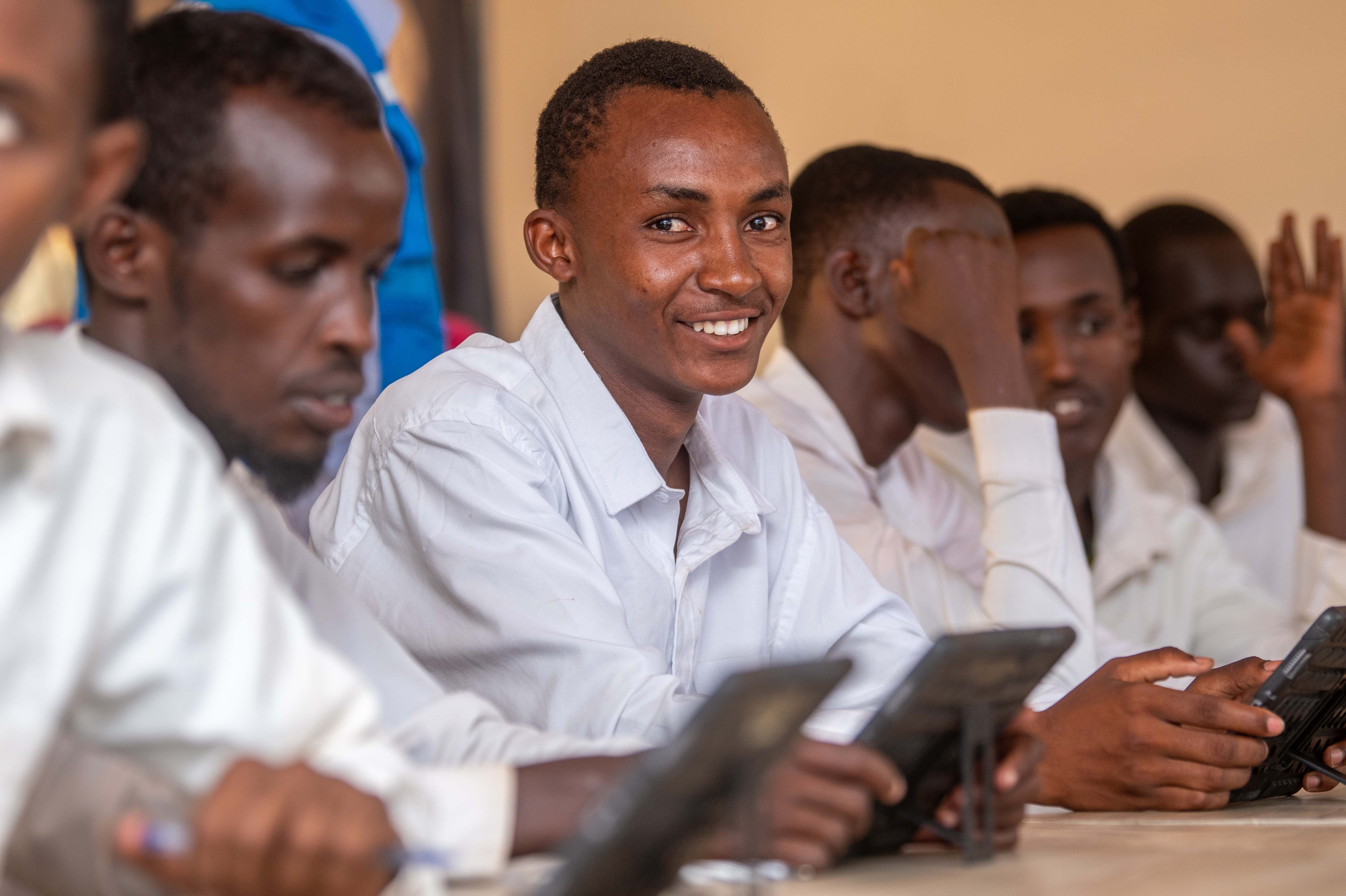 Male students in a classroom using tablets