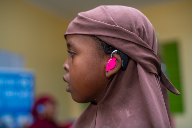 Girl wearing pink hearing aids