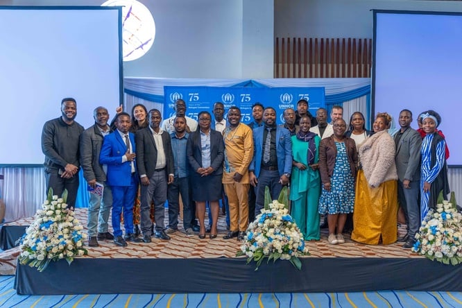 Members of Refugee-Led Organisations, UNHCR and Government pose for a photo during celebrations marking 75 years since the signing of the refugee convention