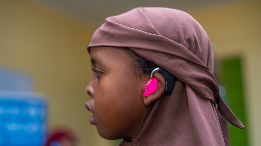 Girl wearing pink hearing aids