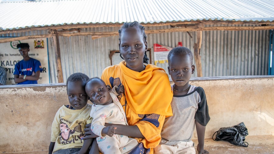 Nyamam, 25 with her three sons aged five, three and six months, poses for a photo at the Kalobeyei Reception Centre in Kakuma.