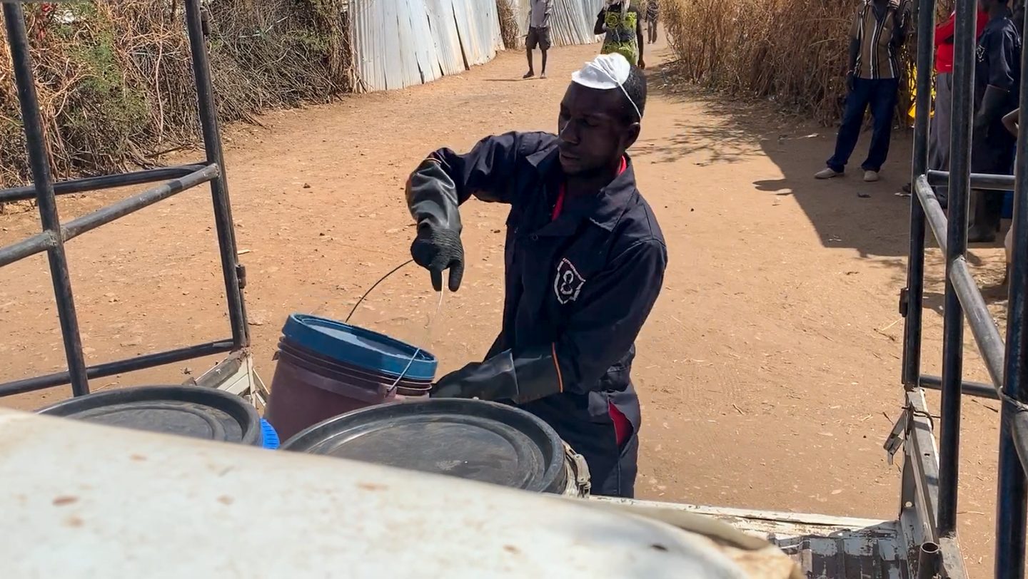David loads sludge onto a waiting paggio in Kakuma refugee camp
