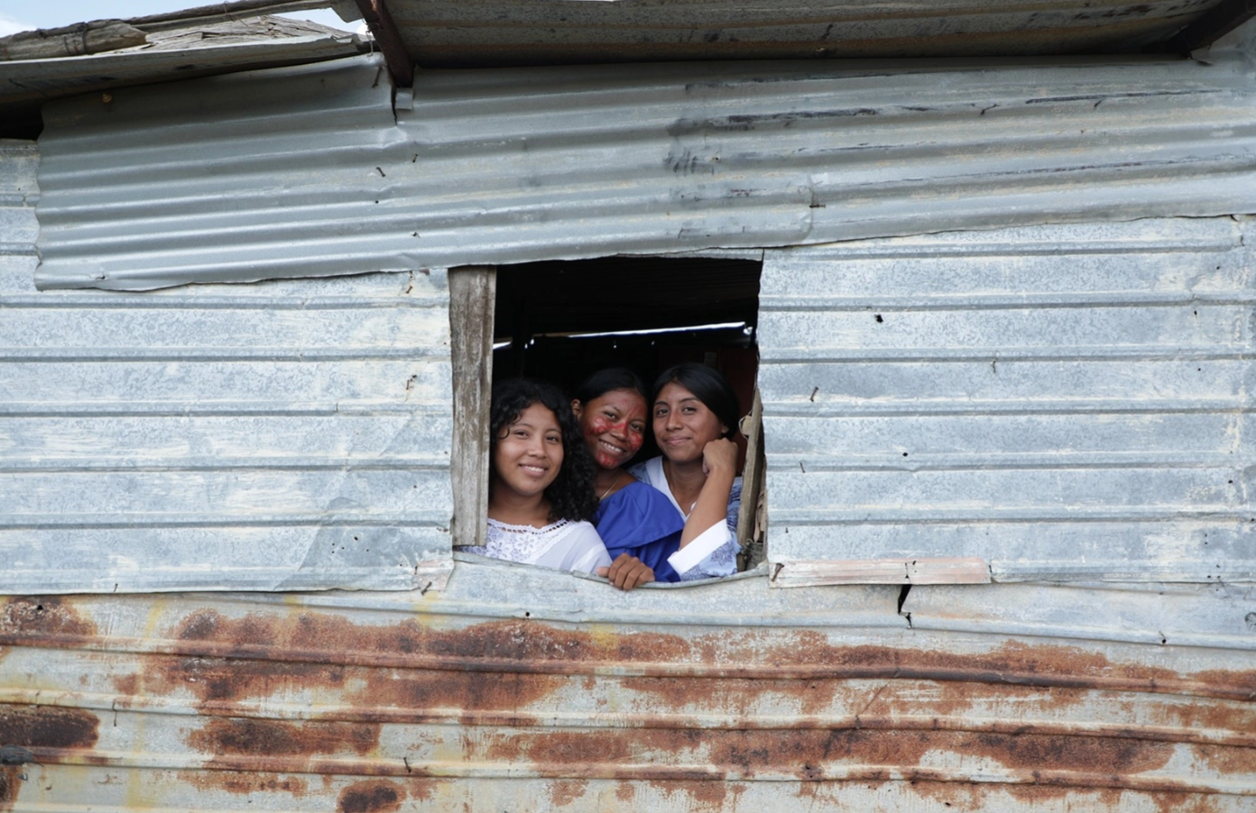 Maria Palacio, a Venezuelan Wayuu teacher and leader, with her family in her house made of zinc sheets.