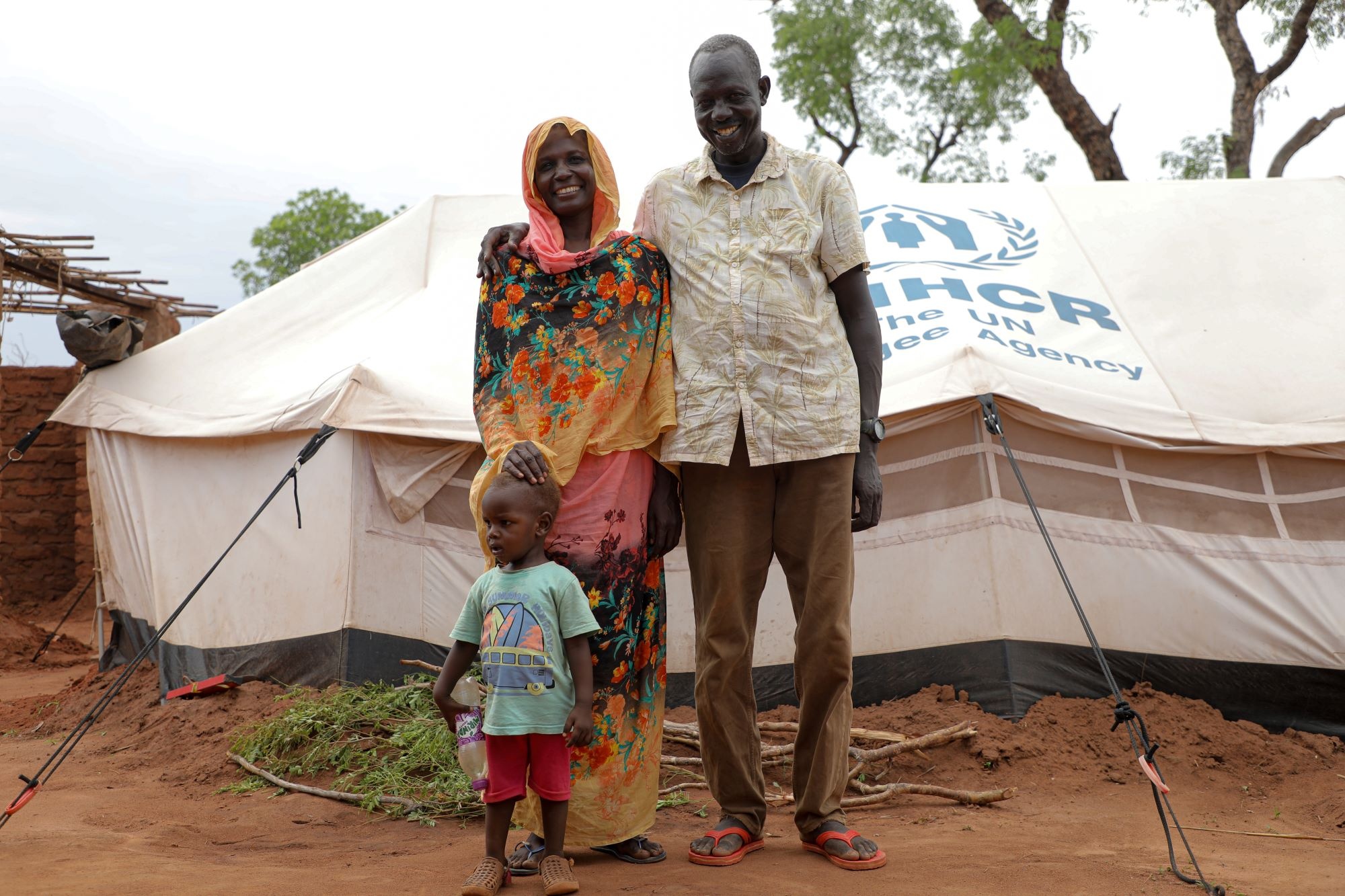 South Sudan. Mahamoud Elnaji Teawa standing in front of his shelter together with his wife and youngest child in Ajoung Thok Camp in South Sudan