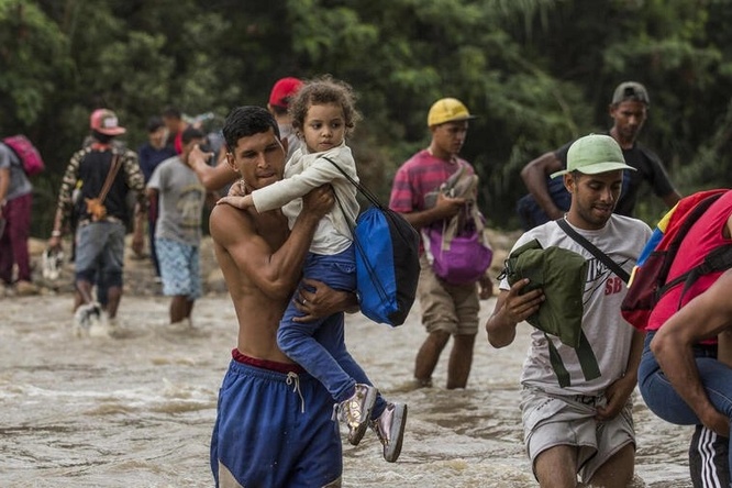 Venezuelans wade across the Tachira River to seek food and other aid in Cúcuta, Colombia.