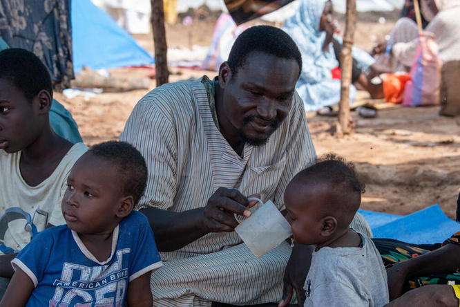 Sudanese refugee Abdallah spends time with his wife and children under their shade  at the UNHCR transit centre in Renk, Upper Nile State, South Sudan, which is hosting  thousands of refugees and returnees. He and his family fled Sudan after the conflict  broke out.  
