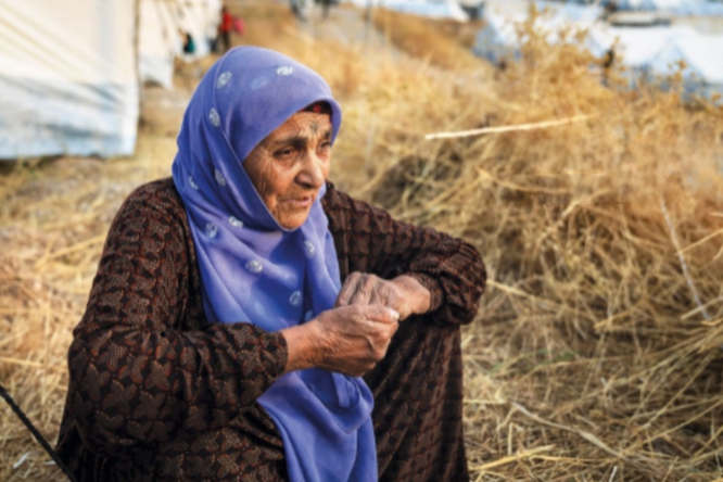 Seventy-year-old Guzeh Mustafa sits outside a shelter at Bardarash camp in Duhok, Iraq. She arrived from north-east Syria with six family members in October 2019 and is in need  of medical assistance.