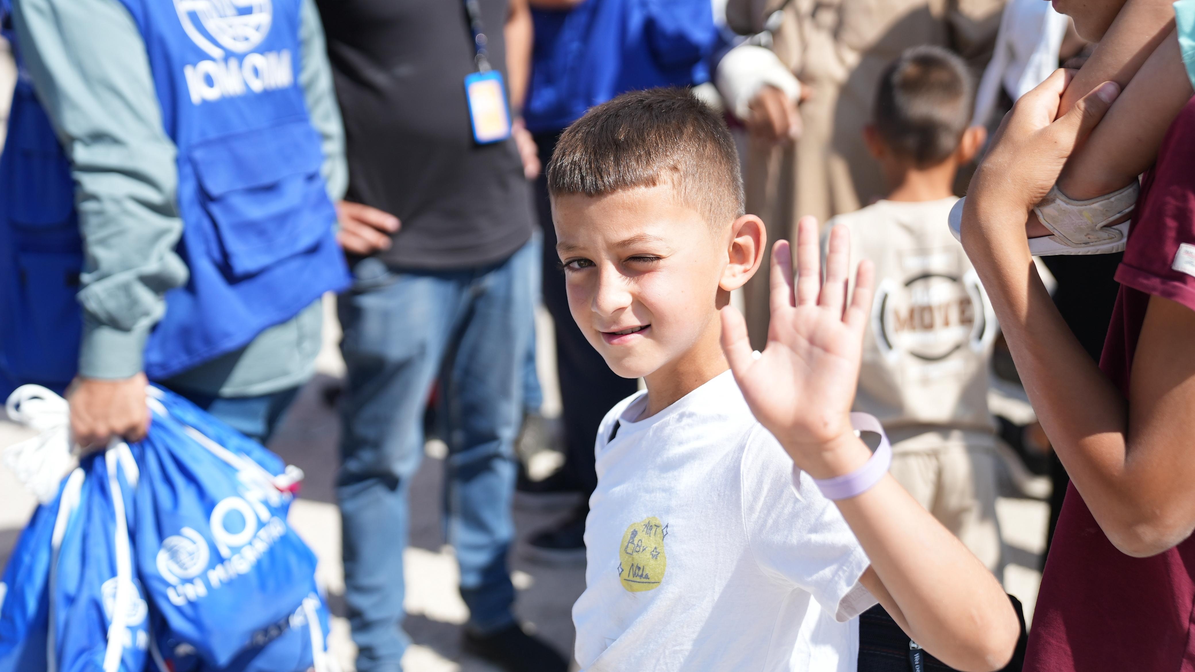 Syrian refugee waiving goodbye before returning to Syria