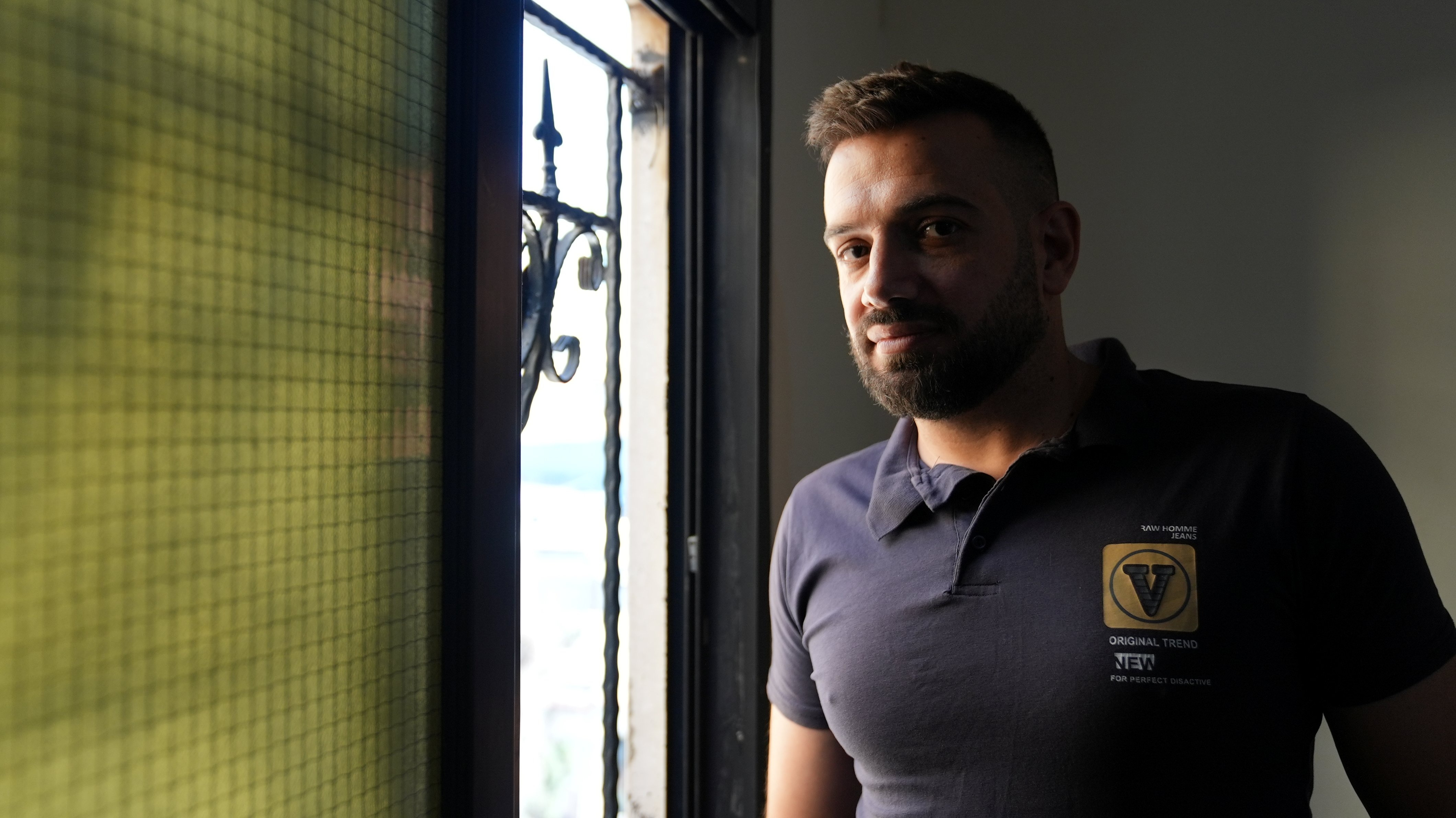 At home, Hussain stands by a window. For years, the lack of official documentation affected his daily life; the confirmation of his nationality case marked a turning point