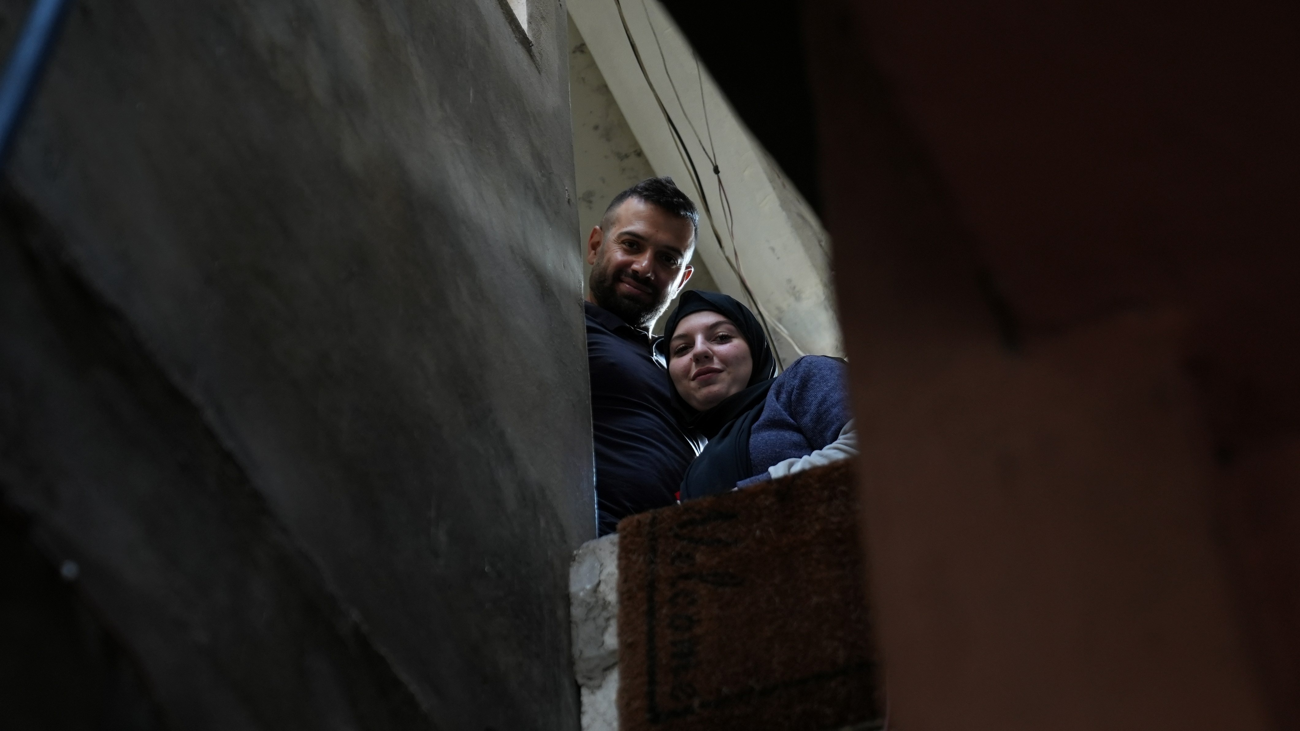 Hussain and his wife stand together at home in Beirut, reflecting on a long journey marked by years of uncertainty due to his lack of legal documentation