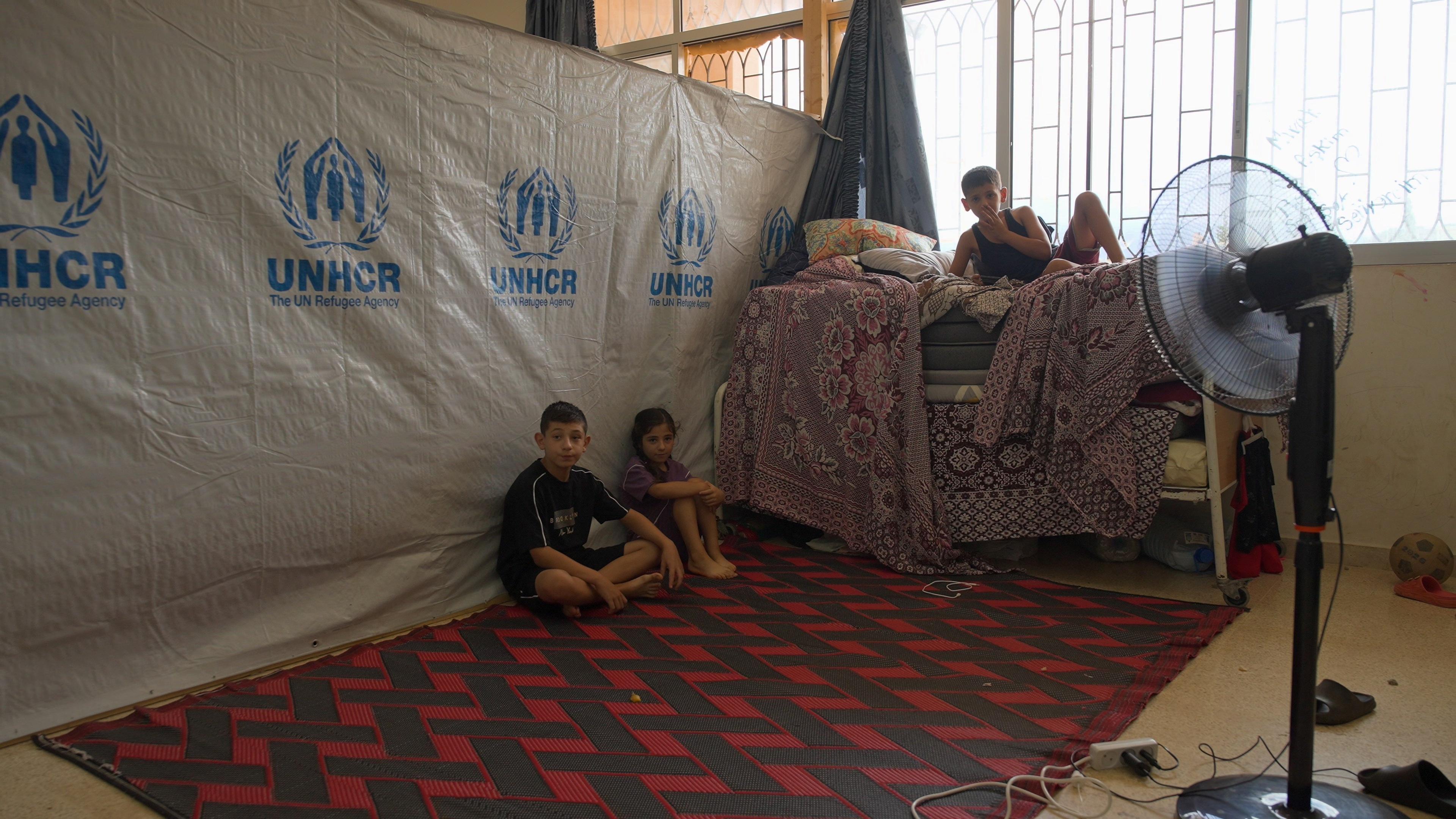 Mohamad, Mehdi and Asinat, inside a classroom that turned into their home during displacement. 