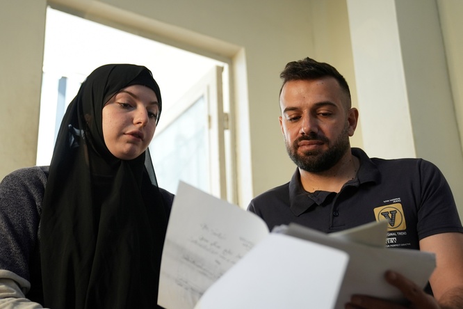 Hussain reviews documents with his wife at their home. Access to legal aid made it possible to address long-standing documentation challenges, including the registration of their marriage.