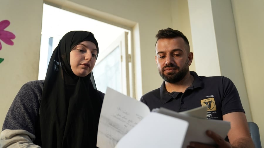 Hussain reviews documents with his wife at their home. Access to legal aid made it possible to address long-standing documentation challenges, including the registration of their marriage.