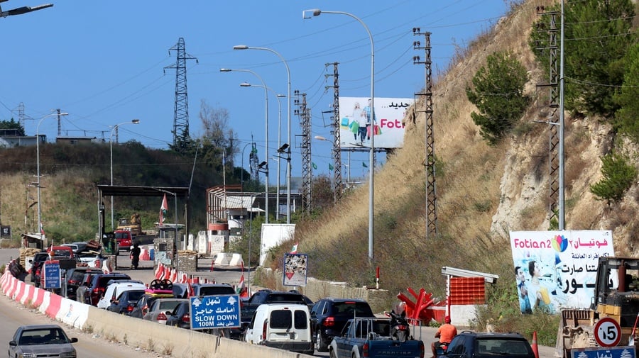 A line of civilian vehicles waits near a checkpoint area in southern Lebanon. The image documents population movement as displaced residents travel toward home communities following ceasefire announcements.