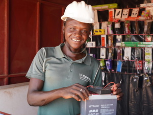 Burkina Faso. Julien Bamogo vérifiant une batterie dans son magasin