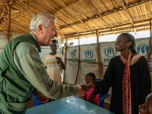 Filippo Grandi shakes hands with Dalia, both smiling.