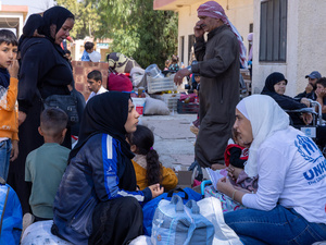 موظفو المفوضية يقدمون المساعدات للسوريين واللبنانيين القادمين إلى معبر جوسية الحدودي في محافظة حمص، سوريا، بعد فرارهم من القصف الإسرائيلي في لبنان.