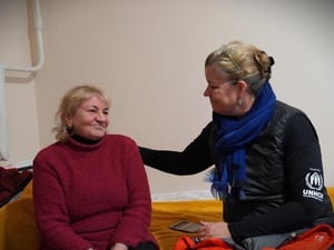 Two women sit together, talking