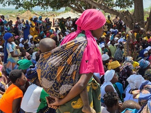 Huge groups of displaced families gather in the open under a large tree