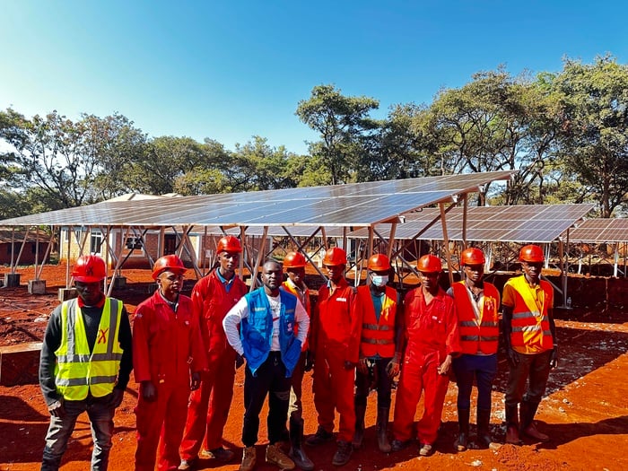 men standing around a solar-powered health centers in Tanzania