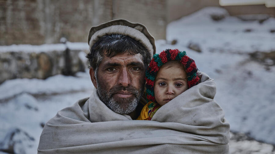 Rehman Gul*, 40, with his two-year old daughter Nazia*, near their home on the outskirts of Kabul. 