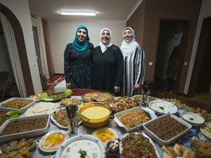 Family of chefs. Syrian refugees Fatima and her daughters Rana and Reem in front of their home cooked dishes.