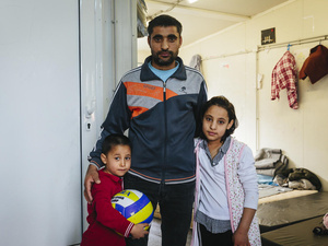 An Afghan asylum-seeker stands with two of his children at a reception centre in Fylakio, Greece, in February 2020.