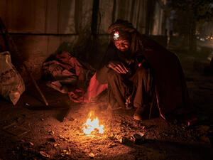 A homeless man seeks warmth from a small fire on the streets of Kabul, Afghanistan, as winter draws in.