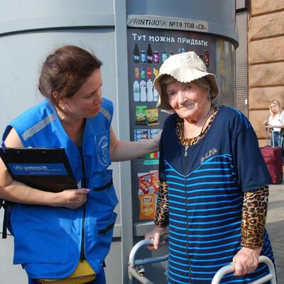 A UNHCR staff member speaks with an elderly woman in Ukraine 
