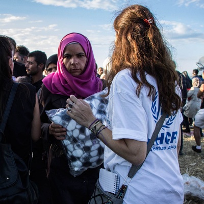 A UNHCR staff member distributes blankets to people waiting to cross the Greek-FYR Macedonian border.