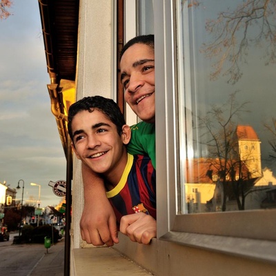 Austria. Syrian refugee kids looking out from their new home in a small town. They are on a resettlement program for Syrian refugees, in cooperation with UNHCR