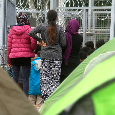 Hungary. Afghan refugee girls patiently waiting as someone is granted access to the tranzit zone in Röszke